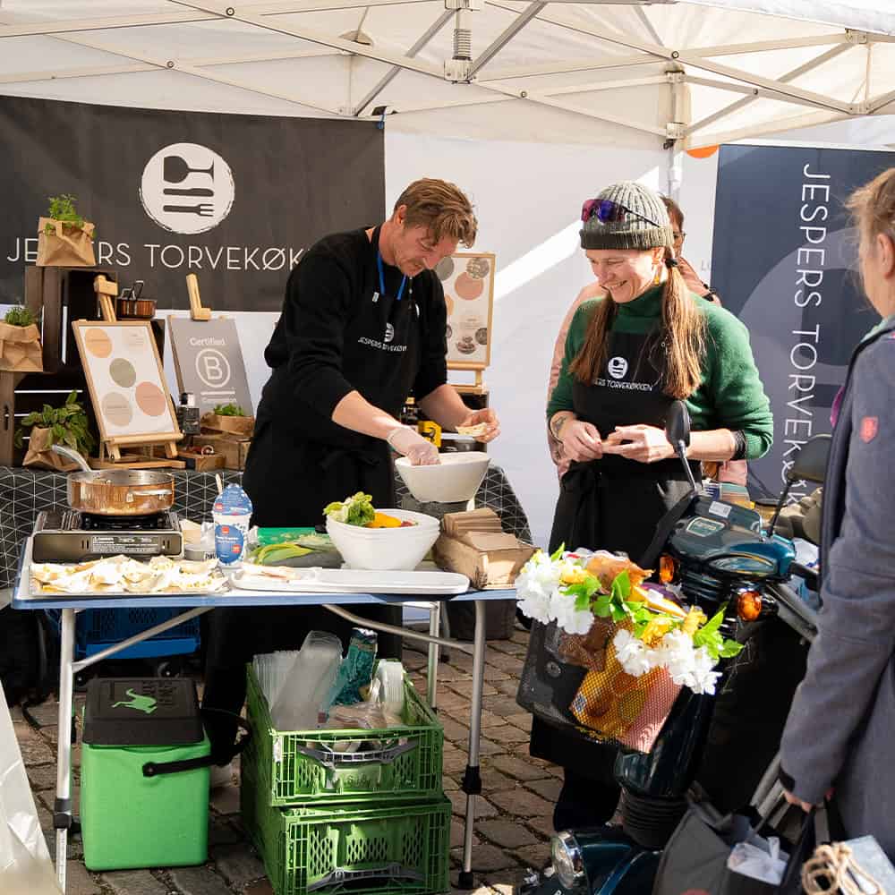 Frivillige uddeler reddet overskudsmad i en lokal Madoase